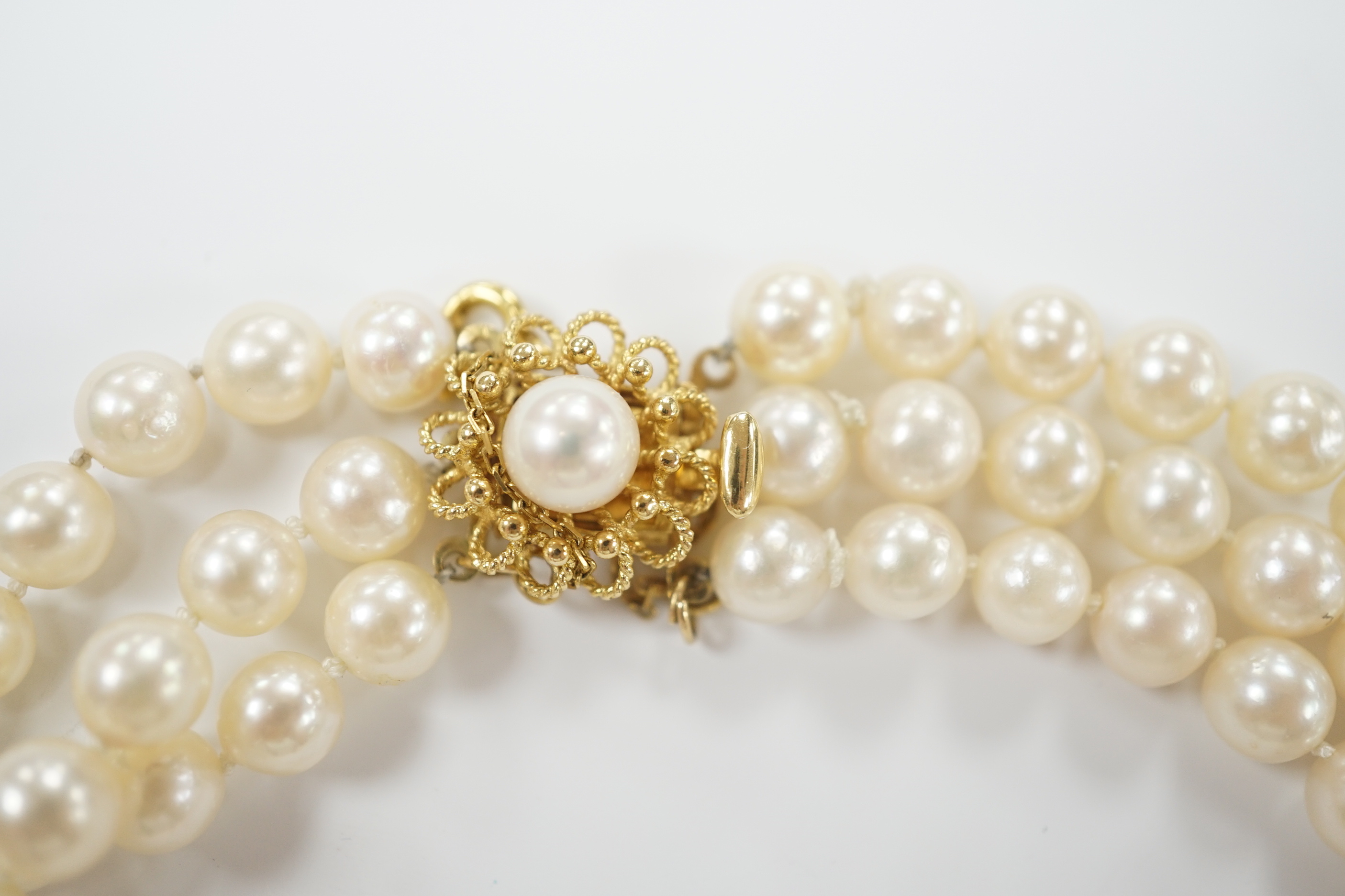 A triple strand cultured pearl set choker necklace, with 750 yellow metal and cultured pearl set clasp, 35cm.